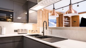 A modern kitchen with a Bosch microwave, a sink, and wooden cabinets.