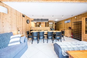 Un intérieur moderne avec un coin repas en bois, un canapé et une petite table.