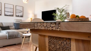 A modern living room with a wooden coffee table, a flat-screen TV, a sofa, and a dining area with a fruit bowl. - Vacation 'Tejita' with Sea View, Wi-Fi and Air Conditioning (Unknown)