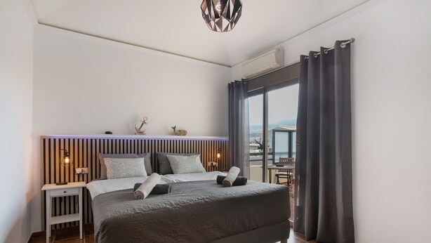 A bedroom with a bed, bedside tables, a nightstand, a window with curtains, and a view of the outside. - Vacation 'Tejita' with Sea View, Wi-Fi and Air Conditioning (Unknown)