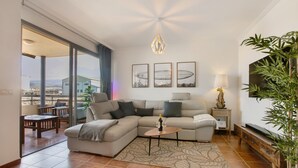 A modern living room with a sectional sofa, a coffee table, a TV, and a large window with a view. - Vacation 'Tejita' with Sea View, Wi-Fi and Air Conditioning (Unknown)