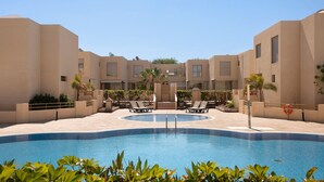 A swimming pool with lounge chairs, palm trees, and a clear sky. - Vacation 'Tejita' with Sea View, Wi-Fi and Air Conditioning (Unknown)