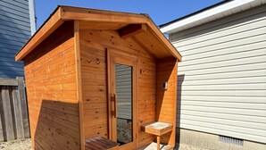 A wooden shed with a door and a small bench outside. - ORS Beach Corporation | Wasaga Beach Rental (Wasaga Beach)