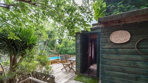 A wooden deck with a pool, a chair, and a sign reading 'LE CASOT.'