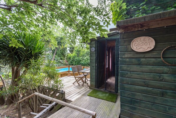 A wooden deck with a pool, a chair, and a sign reading 'LE CASOT.'