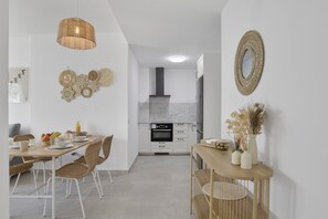 Una cucina moderna con mobili bianchi, forno integrato e lampadario.