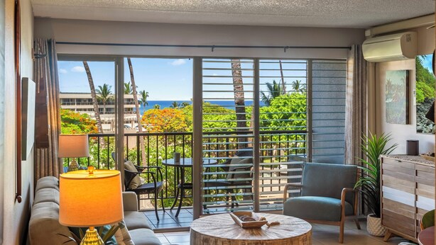 Een moderne hotelkamer met balkon, grote ramen en uitzicht op de oceaan.