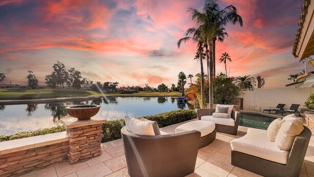A patio with wicker furniture, a stone planter, and a view of a golf course and lake. - 8BR complex w 2 pools, lake view, sleeps 18 (Chandler)