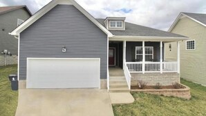 A single-story house with a garage, a covered porch, and a small attached garage. - Beautiful, Cozy  and Airy Retreat with Lots of Character - NO CLEANING FEE (Clarksville)