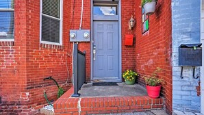 A red brick building with a grey door, a mailbox, and a potted plant on the steps. - Charming Historic 1-bedroom apartment with WiFi, AC in pleasant Richmond (Richmond)