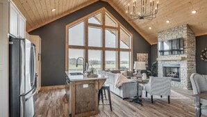 A spacious loft with a kitchen, dining area, and a fireplace.