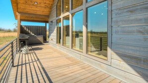 A wooden building with large windows and a covered deck area.