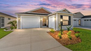 A single-story house with a garage, a front porch, and a well-maintained lawn. - DISCOUNTED 2-bed Patio Villa in Waters Edge, near Eastport. Avail. Nov, Dec, Jan (The villages)