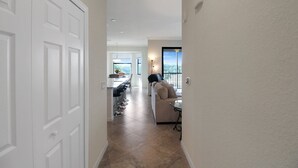 Un couloir menant à une salle à manger avec vue sur l’extérieur.