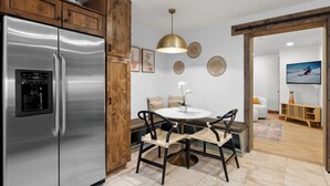 A modern kitchen with a stainless steel refrigerator, wooden cabinets, and a built-in coffee maker.