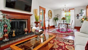 A living room with a fireplace, television, and a dining area with a chandelier.