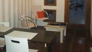 A dining area with a wooden table, chairs, and a ceiling with exposed beams. - Fehu Container Lofts (Villa La Angostura)