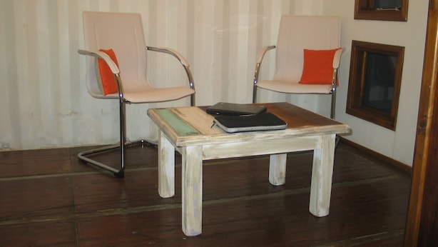 A room with two chairs, a small table, and a window. - Fehu Container Lofts (Villa La Angostura)