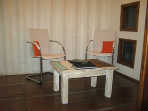 A room with two chairs, a small table, and a window. - Fehu Container Lofts (Villa La Angostura)