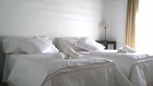 A hotel room with two beds, white linens, a lamp, and a window with curtains. - Hosteria Suyana (San Salvador de Jujuy)