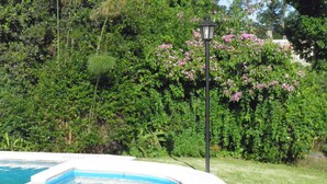 A swimming pool with a light post in a garden. - Hosteria Suyana (San Salvador de Jujuy)