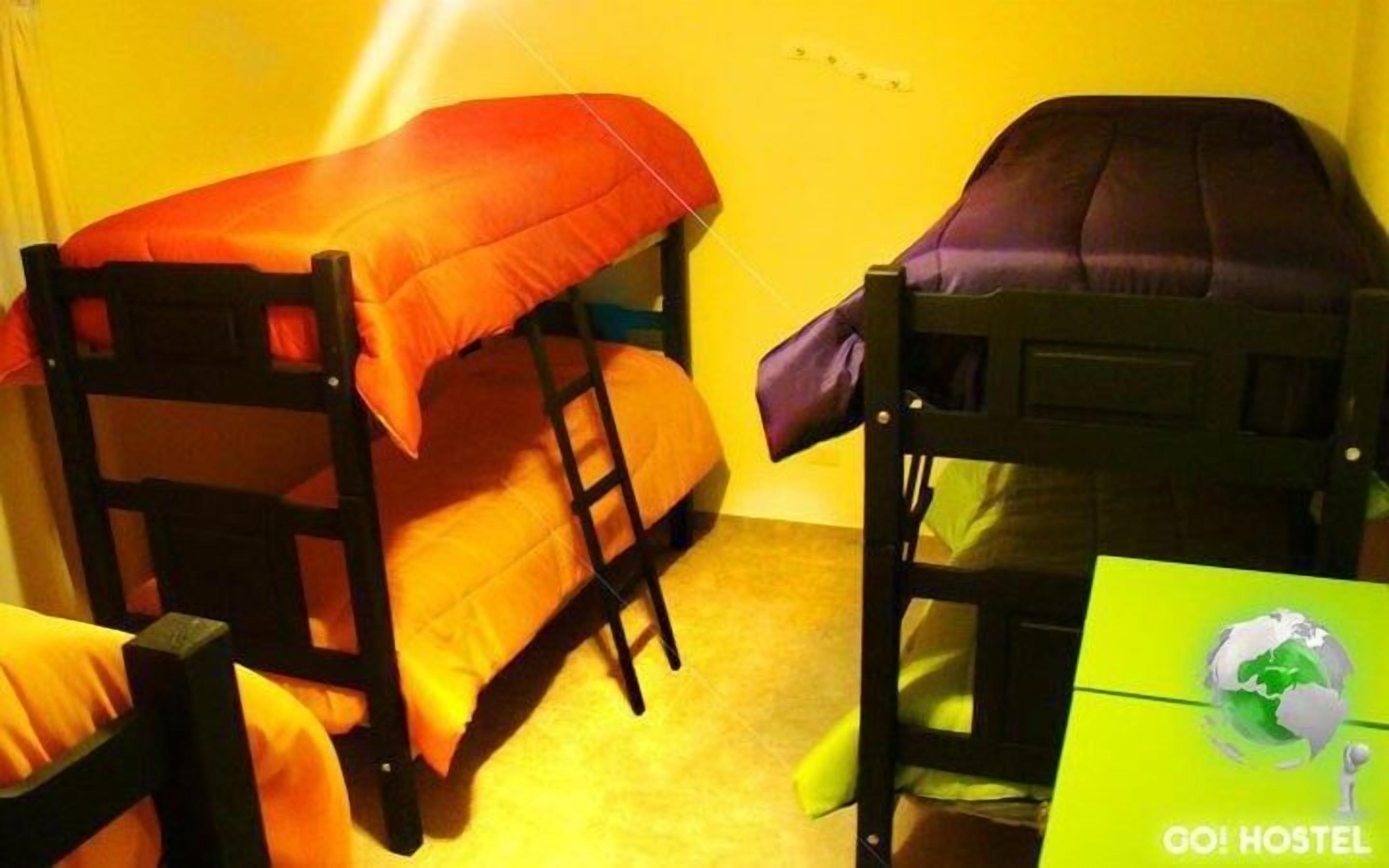 Two bunk beds in a room with yellow walls.