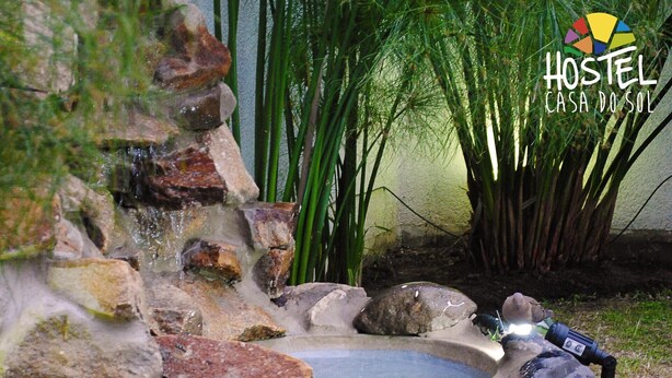 A garden with a small pond surrounded by rocks and bamboo plants.