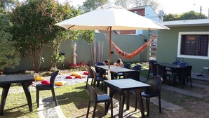 Un patio al aire libre con mesas y sillas, una hamaca y una estatua.