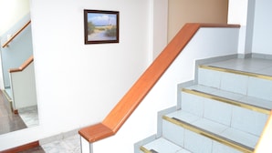 Een trap met houten leuningen en lichtgekleurde treden.