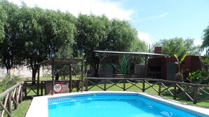 A swimming pool with a wooden deck and a speed limit sign. - La Casona (Gualeguaychú)
