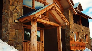 A stone building with a wooden entrance and a sign that reads "Rodica Pehuen". - Ruca Pehuen Eco Lodge de Montaña (Caviahue)