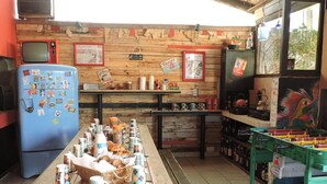 Un caffè rustico con arredamento in legno, un frigorifero azzurro e un tavolo da biliardino.