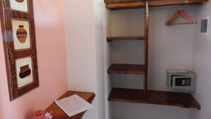 Une pièce avec une étagère en bois, une petite table sur laquelle se trouve un papier, et un cadre photo accroché au mur.