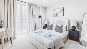 A modern hotel room with a large bed, bedside tables, a desk, and a chair. - Stylish new-build FREE parking, 10min to BHX & NEC (Birmingham)