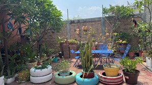 A patio with tire planters, a blue table, and chairs. - Hotel casa zoque colonial  (Tuxtla Gutiérrez)