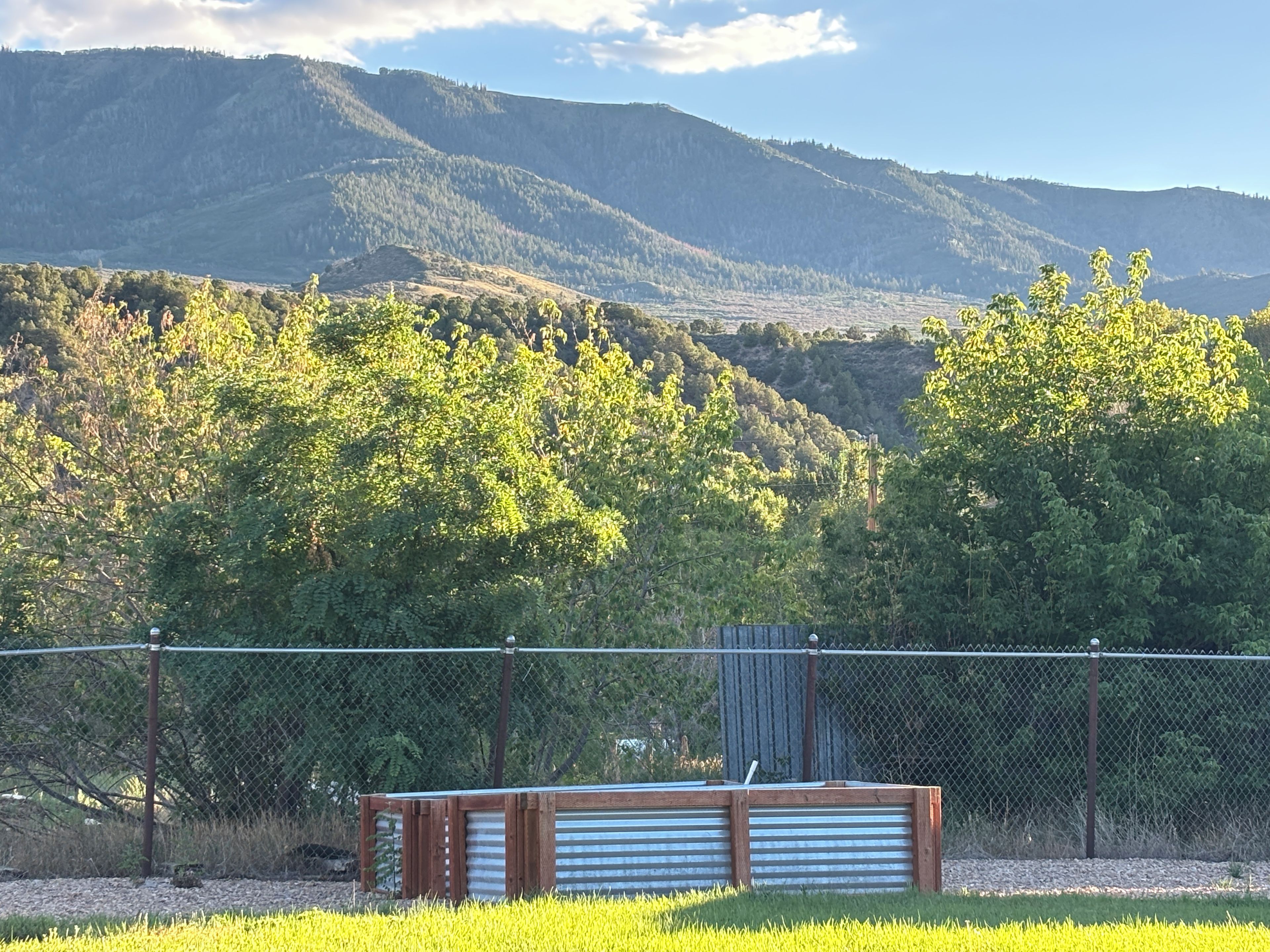 A fenced area with a bench and a view of a mountainous landscape.