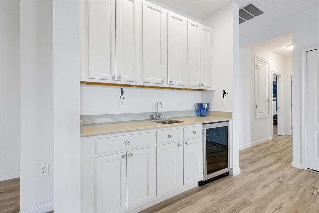 A kitchen with white cabinets, a sink, and a dishwasher.