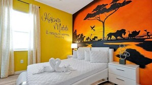 A bedroom with a bed, a nightstand, a wall mural, and curtains. - 12BR Solterra Mansion + Arcade Game Room & Pool (Davenport)