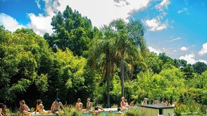 A group of people relaxing by a pool surrounded by lush greenery. - Senador Dupont (Tigre)