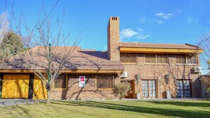 A two-story brick house with a tiled roof, a chimney, and a garage. - Casa Bonita (Neuquén)