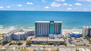 A hotel with a large building and a parking lot in front. - Seagull Heights! 2-BR 2-BA OCEANFRONT Royal Garden Resort Condo In&Outdoor Pools (Murrells Inlet)