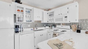 A modern kitchen with white cabinets, a built-in microwave, and a coffee maker. - Seagull Heights! 2-BR 2-BA OCEANFRONT Royal Garden Resort Condo In&Outdoor Pools (Murrells Inlet)
