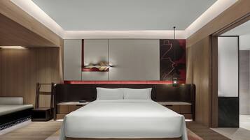 A modern bedroom with a large bed, wooden paneling, and a red accent wall.