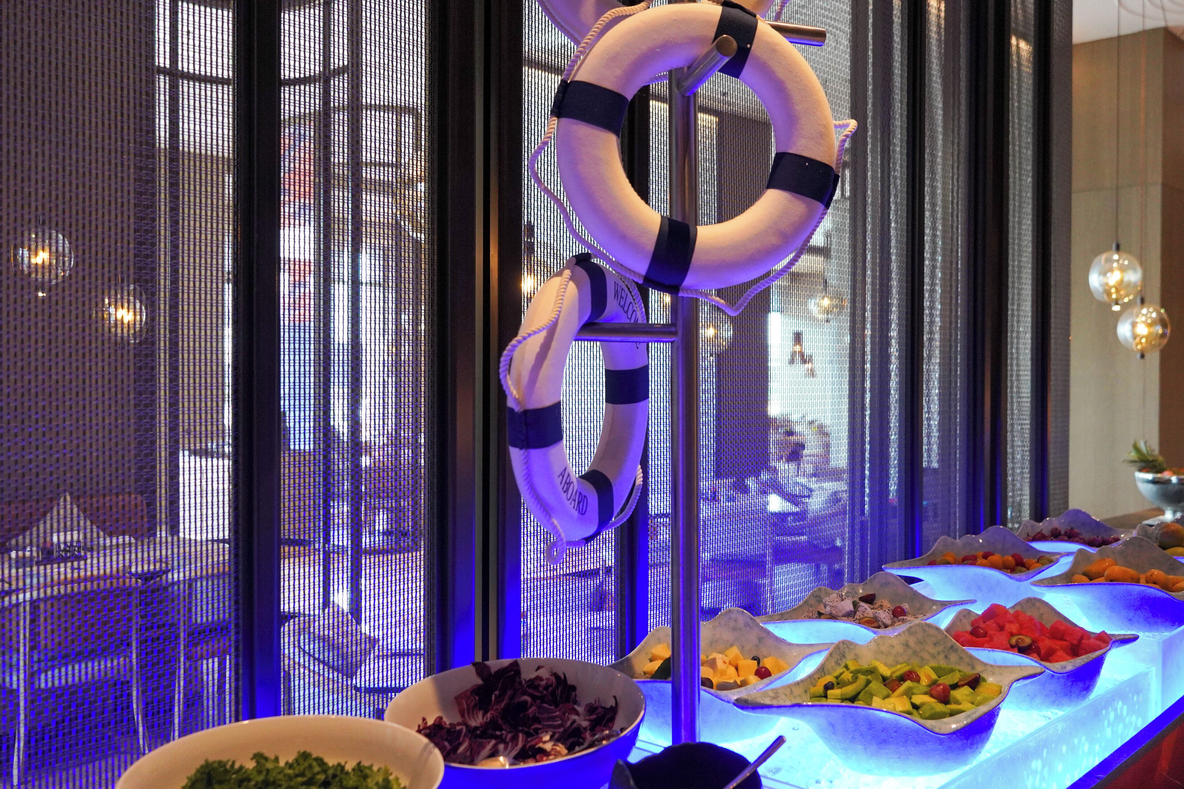 Ein Buffet mit verschiedenen Speisen und einem Rettungsring, der an einem Metallgestell hängt.