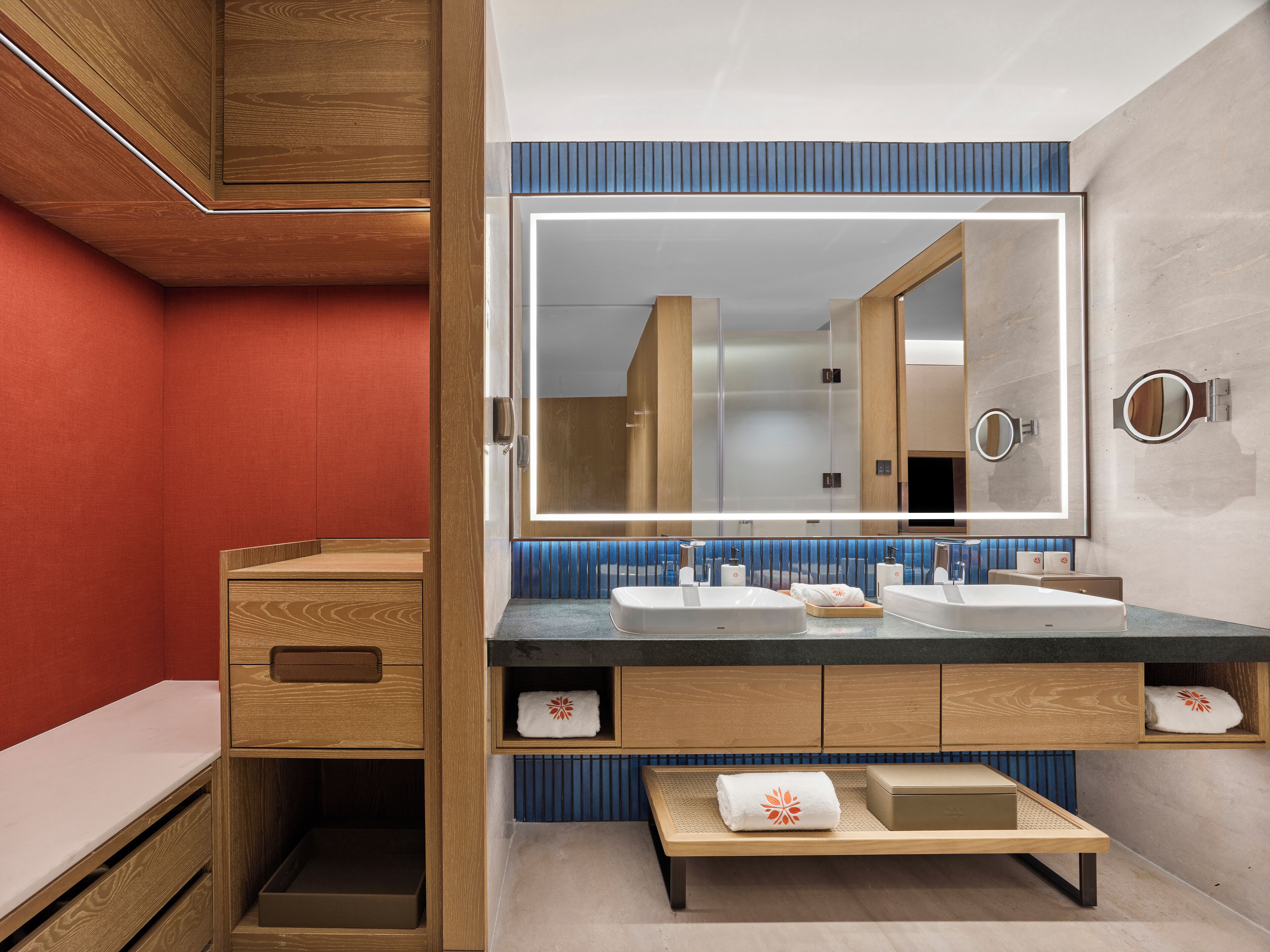 Une salle de bain moderne avec un meuble-lavabo en bois, deux vasques, un grand miroir et un porte-serviettes.