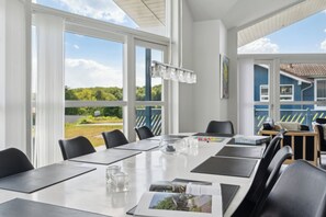 Ein Konferenzraum mit großem Tisch, Stühlen und Blick ins Freie.