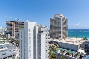 Un hotel Marriott con vista al océano, rodeado de otros edificios y grúas de construcción.