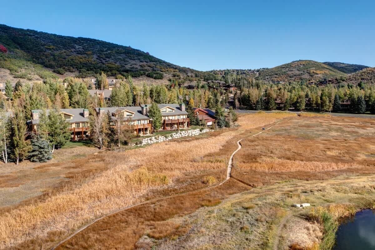 A lodge with multiple buildings, surrounded by a natural landscape with hills and trees.
