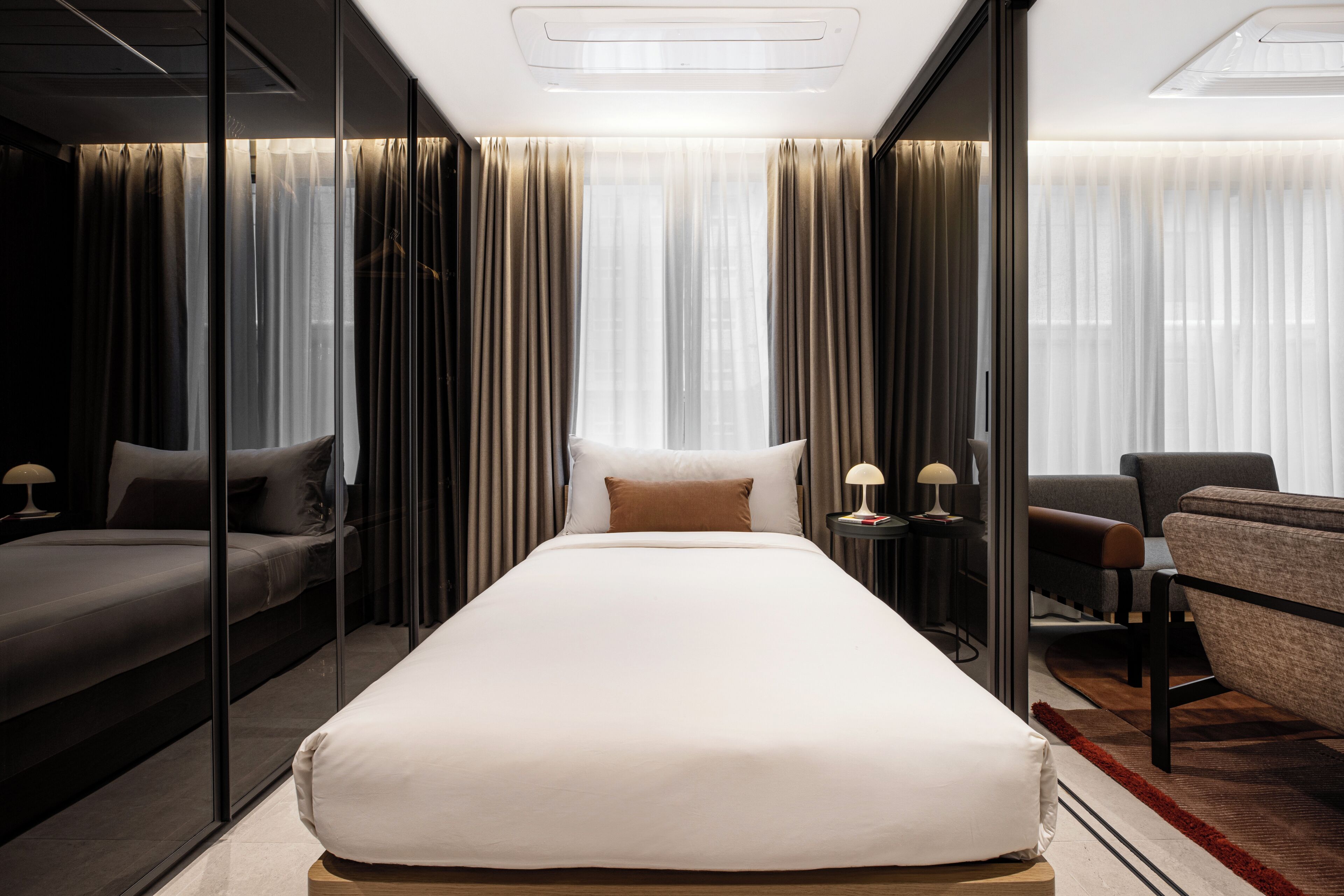 Een moderne hotelkamer met een groot bed, een bank, een bureau en een stoel.