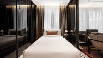 Een moderne hotelkamer met een groot bed, een bank, een bureau en een stoel.